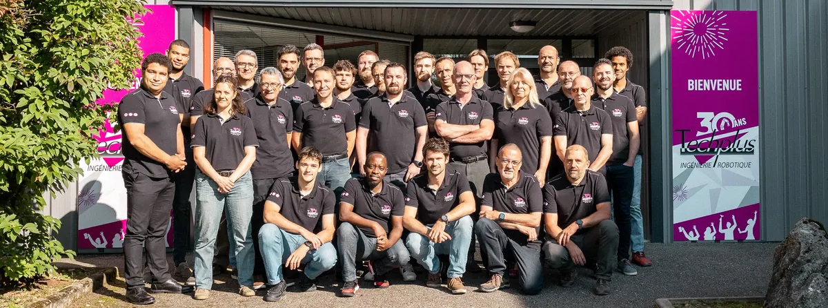 L’équipe Techplus, une trentaine de personnes en polo noir, devant l’entrée du site de Reignier.